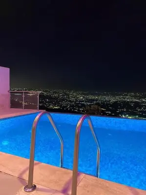 a swimming pool with a view of a city at night at villa rose3 in Mūbiş