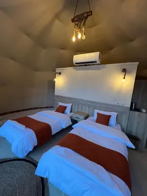 a room with two beds in a room at Bedouin Camp&tour in Wadi Rum