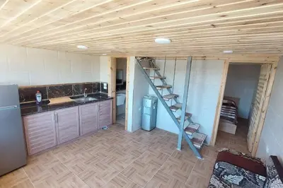 a kitchen with a staircase in the middle of a room at أكواخ وشقق كرم العنب عجلون in ‘Ayn Jannā