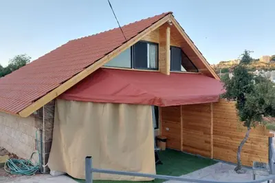 a house with a red awning on top of it at أكواخ وشقق كرم العنب عجلون in ‘Ayn Jannā