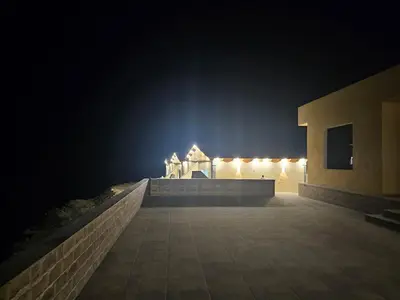 a building at night with lights in the background at Ramses Tafilah Lodge نزل رمسيس الطفيلة in At-Tafilah
