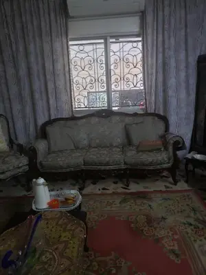 a living room with a couch and a window at Al Otaibi in Umm Uthainah