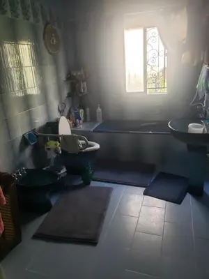 a bathroom with a tub and a toilet and a sink at Al Otaibi in Umm Uthainah