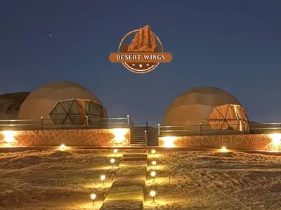 a group of domes with a sign that reads desert wings at RUM WINGS BUBBLES lUXURY CAMP in Wadi Rum