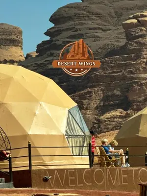 a group of people sitting in chairs in front of a tent at RUM WINGS BUBBLES lUXURY CAMP in Wadi Rum
