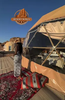 a woman standing in front of a tent at RUM WINGS BUBBLES lUXURY CAMP in Wadi Rum
