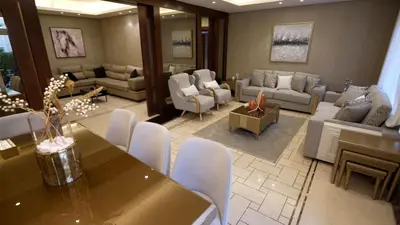 a large living room with a table and chairs at Open sooq in Al Bunayyāt ash Shamālīyah