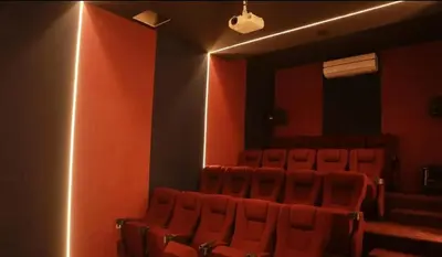 an empty auditorium with red chairs and a spotlight at Open sooq in Al Bunayyāt ash Shamālīyah