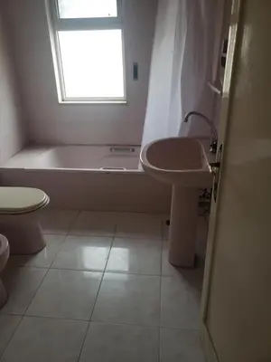 a bathroom with a tub and a sink and a toilet at Al Otaibi in Umm Uthainah
