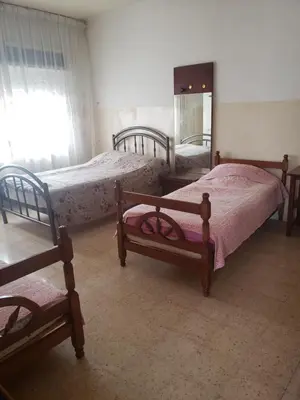 a bedroom with two beds and a mirror at Al Otaibi in Umm Uthainah