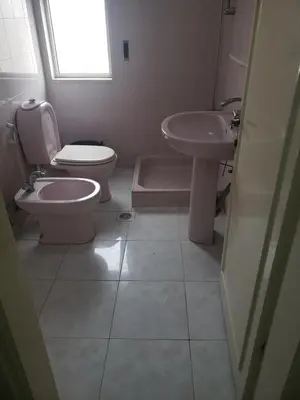 a bathroom with a toilet and a sink at Al Otaibi in Umm Uthainah