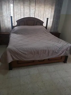 a bed in a bedroom with a wooden frame at Al Otaibi in Umm Uthainah