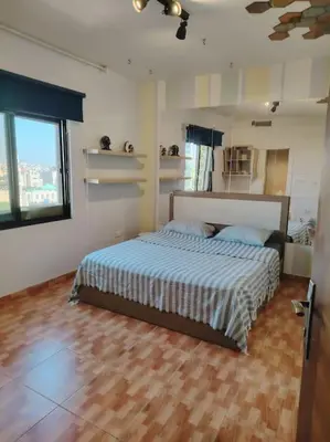 a bedroom with a bed with a wooden floor at Cozy modern 2 bedroom apartment in Amman