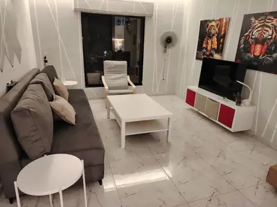 a living room with a couch and a tv at Cozy modern 2 bedroom apartment in Amman