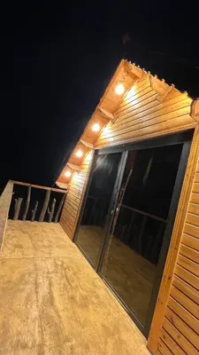 a house with glass doors and lights on it at منتجع برمودا Bermuda resort in Ajloun