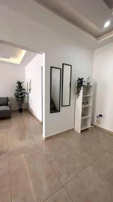 a living room with three pictures on the wall at Modern & New 3-BR Entire Apt - Prime Location! in Rujm ash Sharāʼirah