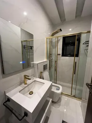 a white bathroom with a sink and a shower at Modern & New 3-BR Entire Apt - Prime Location! in Rujm ash Sharāʼirah