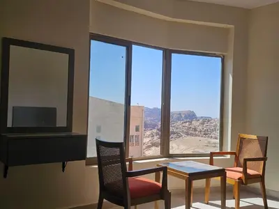 a room with a table and chairs and a large window at Petra Summit Hotel in Petra