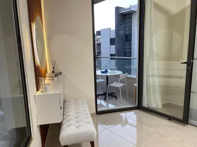 a white stool in a room with a view of a table at السابع in Amman