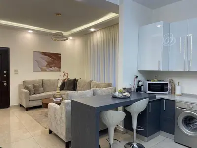 a kitchen and living room with a couch and a table at السابع in Amman