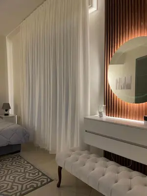 a bedroom with a bed and a mirror and a bench at السابع in Amman