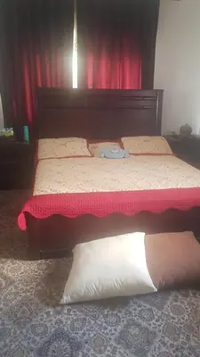 a bedroom with two beds with red curtains at ram77 in Al Salt