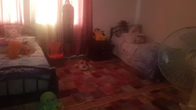 a bedroom with two beds and stuffed animals on the floor at ram77 in Al Salt