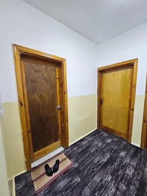 an empty room with two doors and a pair of shoes at Travelers Rest in Wadi Musa
