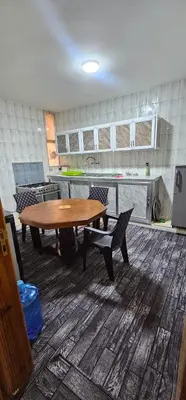 a kitchen with a wooden table and a table and chairs at Travelers Rest in Wadi Musa