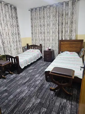 a bedroom with two beds and a table and chairs at Travelers Rest in Wadi Musa