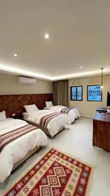 a bedroom with three beds and a rug at Jawad Hotel by Sandra in Amman