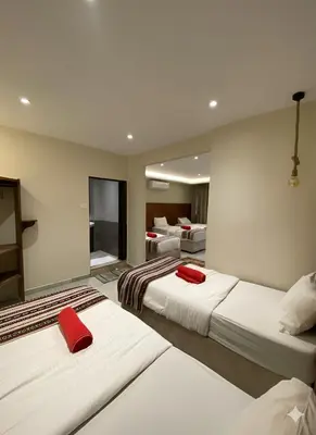 a hotel room with three beds with red pillows at Jawad Hotel by Sandra in Amman