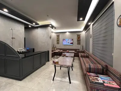 a restaurant with benches and tables in a room at Jawad Hotel by Sandra in Amman