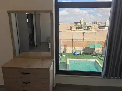 a room with a window with a view of a pool at Aeropuerta Mini Villa - Private self check-in Layover near Airport in Al Qasţal