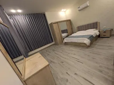 a bedroom with a bed and a wooden floor at Aeropuerta Mini Villa - Private self check-in Layover near Airport in Al Qasţal