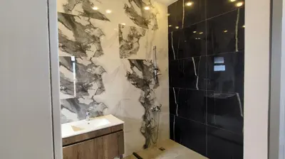 a black and white bathroom with a sink and a shower at Aeropuerta Mini Villa - Private self check-in Layover near Airport in Al Qasţal