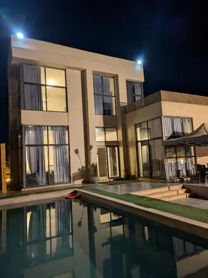 a villa with a swimming pool at night at Aeropuerta Mini Villa - Private self check-in Layover near Airport in Al Qasţal
