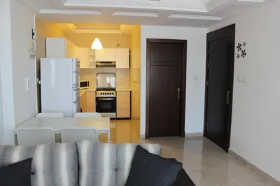 a living room with a couch and a kitchen at Cosy appartement in Umm Uthainah