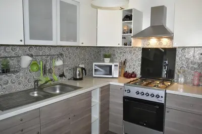 a kitchen with a sink and a stove top oven at Cozy apartment Amman in Umm Uthainah