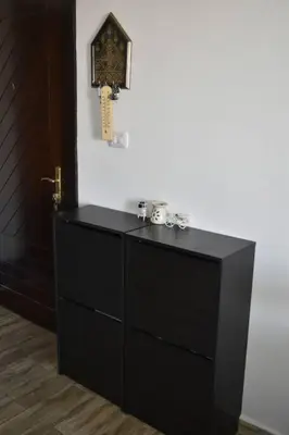 a black dresser with a clock on a wall at Cozy apartment Amman in Umm Uthainah