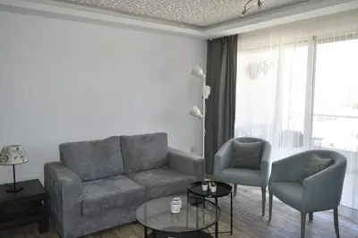 a living room with a couch and two chairs at Cozy apartment Amman in Umm Uthainah