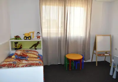a bedroom with a bed and a table and a chair at Cozy apartment Amman in Umm Uthainah
