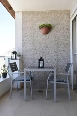 a table and chairs on a patio with a plant at Cozy apartment Amman in Umm Uthainah