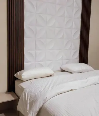 a white bed with two pillows on top of it at Flat In Shafa Badran in Ţāb Kirā‘