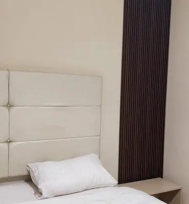 a bedroom with a white bed and a headboard at Flat In Shafa Badran in Ţāb Kirā‘