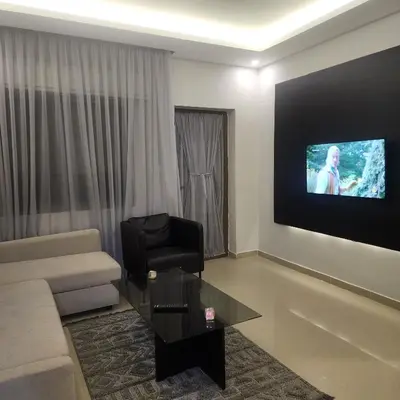 a living room with a couch and a tv on a wall at Flat In Shafa Badran in Ţāb Kirā‘