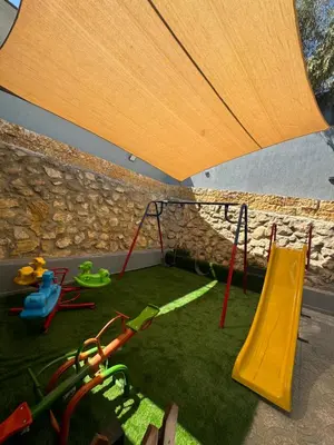 a play area with swings and a playground at شاليه بيت التل HILLHOUSE Chalet in Al Maşţabah