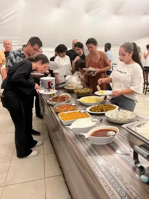 a group of people standing around a buffet table with food at Moon rum 2 in Disah