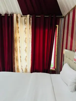 a bedroom with red curtains and a white bed at Moon rum 2 in Disah