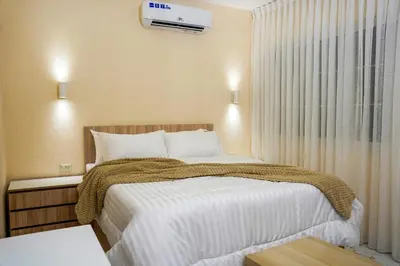 a bedroom with a bed and a air conditioner on the wall at Hawari Group in Umm Uthainah